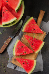 Wall Mural - Fresh raw watermelon cut into pieces on  gray stone background. Selective focus. Top view. Copy space.