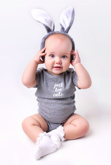 Wall Mural - Baby in rabbit bunny easter costume on white background.