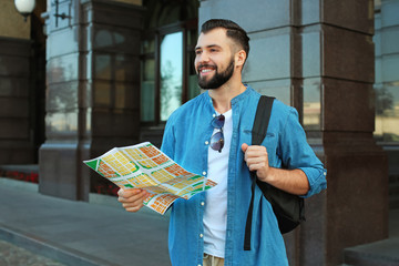 Wall Mural - Young male tourist with map on the street