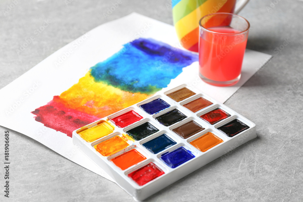 Watercolor painting of rainbow on grey table