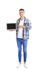 Wall Mural - Young man pointing at laptop screen against white background