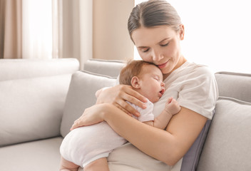 Sticker - Young mother holding sleeping baby at home