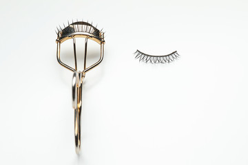 Wall Mural - Curler and false eyelashes on white background