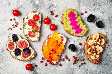 Poster - Healthy breakfast toasts with peanut butter, banana, chocolate granola, avocado, watermelon radish, persimmon, pomegranate, chia seeds, tomato, figs, blackberry.