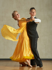 Attractive young couple of children dancing ballroom dance in studio