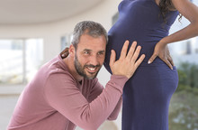 Young Family , Caucasian Man Put His Ear To The Belly Of His Black Pregnant Wife And Listening Unborn Baby's Heartbeat