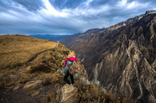 Young Woman Meditate Above The Deepest Canyon Colca. Panoramic Breathtaking View Of Peruvian Village And Canyon Colca , Peru, South America