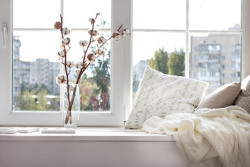 cushions and a knitted plaid on the windowsill.