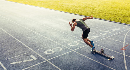 Wall Mural - sprinter taking off from starting block on running track