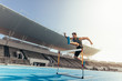 Athlete jumping over an hurdle on running track