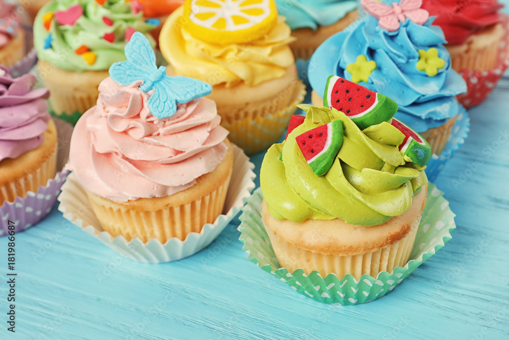 Beautiful cupcakes on color wooden background