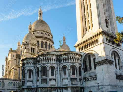 Plakat Trzy czwarte tylni widok kopuła bazylika Święty serce Paryż przy wschodem słońca z kwadratowym steeple w przedpolu.
