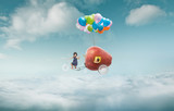 Happy sister enjoy with fantasy apple cycle ride  and floating in sky with bunch of colorful balloons .
