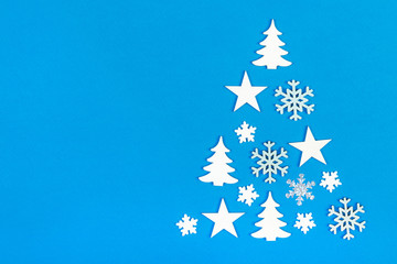 christmas tree made from christmas decorations on blue background with empty copy space for text. holiday and celebration creative concept. new year and christmas postcard or invitation. top view