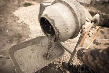 worker pours concrete mortar on a construction site