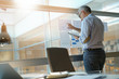 © goodluz - Businessman analyzing results charts hanged on office window