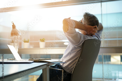 Fotomural Businessman in office relaxing in chair