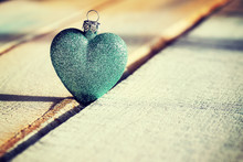 Christmas Green Bauble Heart On A Wooden Background, Color Toned Photo, Selective Focus.