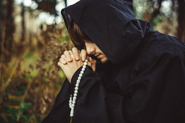 Wall Mural - a monk in robes praying in the woods