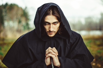 a monk in robes praying in the woods