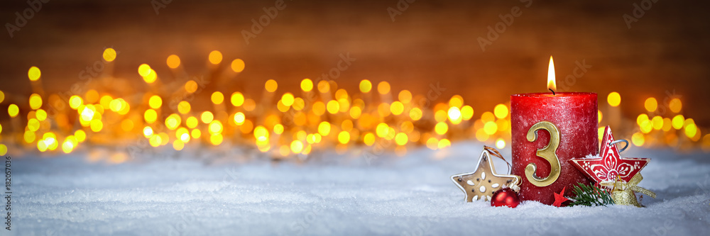 Stock-Foto „Dritter Advent schnee panorama Kerze mit Zahl dekoriert weihnachten Aventszeit holz hintergrund lichter bokeh / third sunday advent“