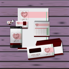 stationary templates of heart design of business stationery over purple wooden background