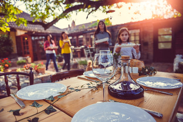 Family preparing dining table at backyard patio