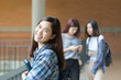 © ChayTee - Smiling asian student girl posing in the campus, holding books and looking at camera, learning and education concept.