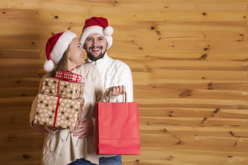 Young woman and young man with beard in Santa Claus hat