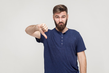 Wall Mural - Portrait of unsatisfied bearded man with thumbs down