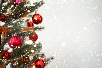 close-up of christmas tree with ornament, decoration and light bokeh with snowfall on winter backgro