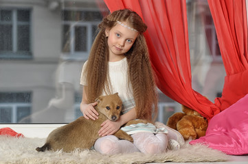 Wall Mural - Girl sitting with a puppy in her arms