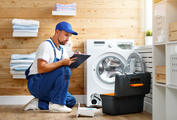 working man   plumber repairs  washing machine in   laundry.