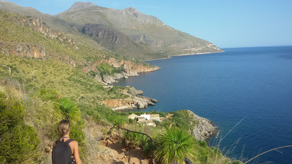 a girl explores the Zingaro nature reserve on Sicily island in Italy