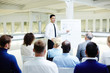 © pressmaster - Educational event in conference hall - attendants listening to speech of young confident financier or expert sharing his working strategies