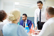 © pressmaster - One of young politicians listening to more experienced colleague from other country at seminar
