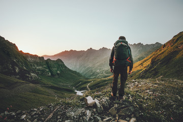 man hiking at sunset mountains with heavy backpack travel lifestyle wanderlust adventure concept sum
