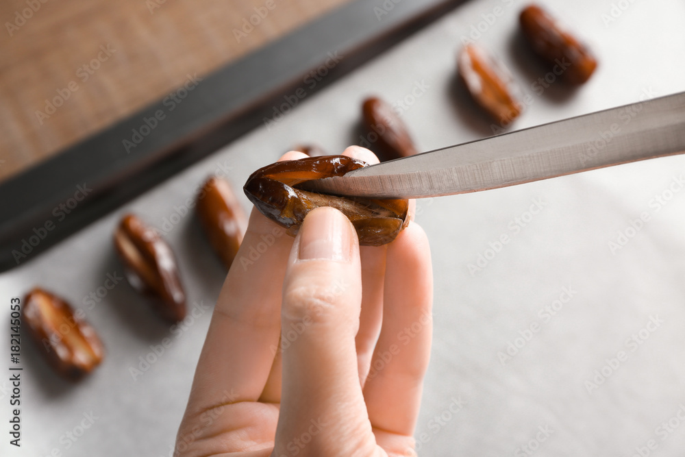 Woman removing pit from ripe date, closeup
