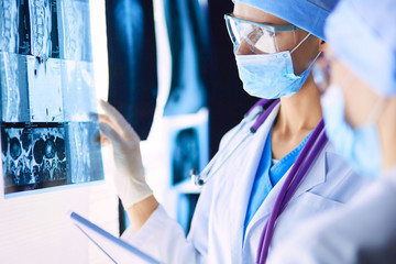 Wall Mural - Two female women medical doctors looking at x-rays in a hospital