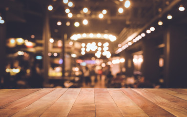 Wall Mural - Wood table top (Bar) with blur light bokeh in dark night cafe,restaurant background .Lifestyle and celebration concepts