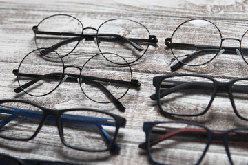 Wall Mural - Six eyeglasses on a light wooden background