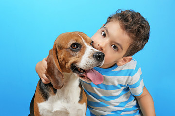 Wall Mural - Cute boy with dog on color background