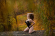 © Михаил Решетников - Young, sexy, chubby Girl in black lace body with very large Breasts lying in the yellow grass in the forest. Autumn, overcast.