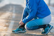 Woman runner tying shoelaces. Healthy lifestyle.