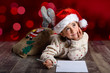 © javiindy - Adorable little girl wearing santa hat writing Santa letter