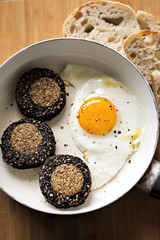 Black & White pudding roulade and fried egg on white pan with bread