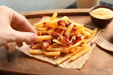 Wall Mural - Person eating french fries and bacon at table