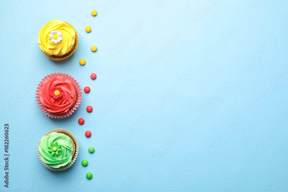 Tasty cupcakes on color background