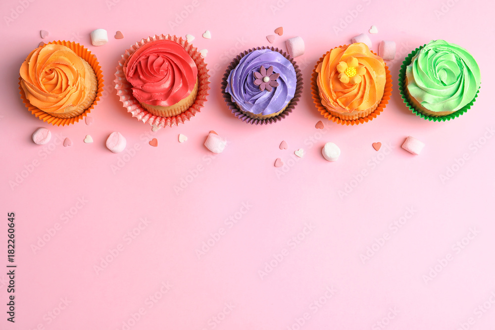 Tasty cupcakes on color background