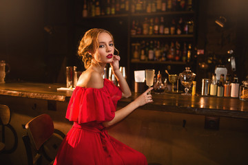 Portrait of woman in red dress at the bar counter